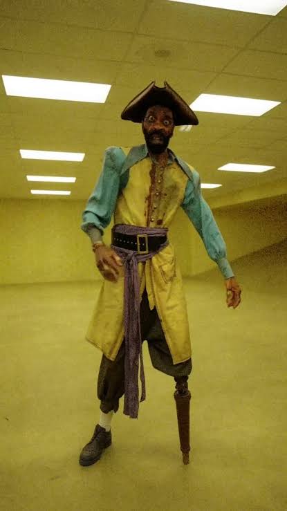A pirate-like figure standing in the Backrooms