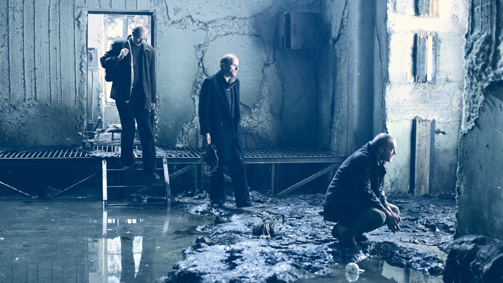 A ruined interior from Stalker with figures amid debris and water
