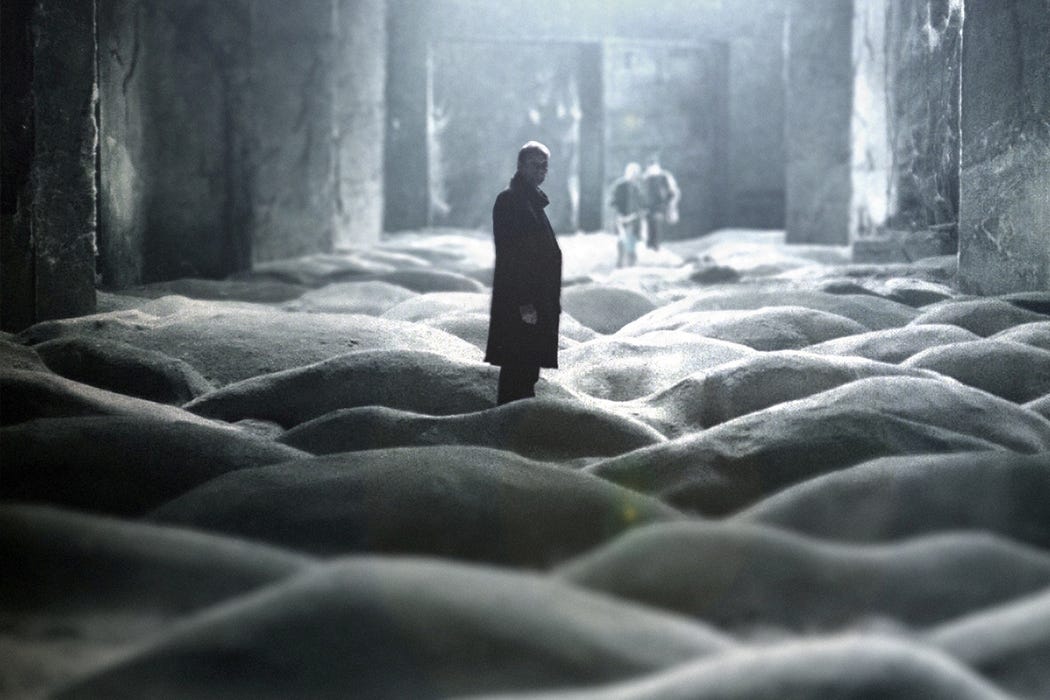 A still from Stalker showing a figure in a textured industrial Zone landscape
